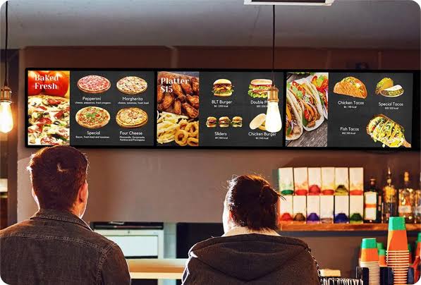 Sipariş vermek için Vista Kurumsal tarafından yapılan dijital menü board kurulumu ekranlarını inceleyen restoran müşterileri